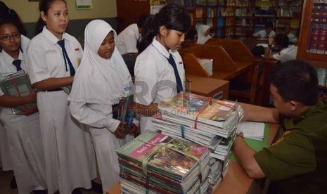 petugas menata buku-buku kurikulum 2013 yang dikemblikan siswa kepada pihak sekolah di Sekolah Menegah Pertama Negeri 56, Jakarta Selatan, Senin (15/12).