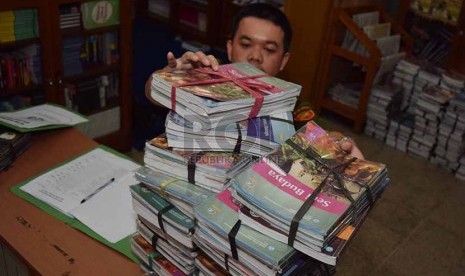 petugas menata buku-buku kurikulum 2013 yang dikemblikan siswa kepada pihak sekolah di Sekolah Menegah Pertama Negeri 56, Jakarta Selatan, Senin (15/12).