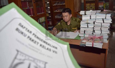 petugas menata buku-buku kurikulum 2013 yang dikemblikan siswa kepada pihak sekolah di Sekolah Menegah Pertama Negeri 56, Jakarta Selatan, Senin (15/12).