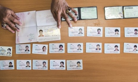 Petugas menata kartu identitas puluhan WNA asal Tiongkok yang ditangkap Polda Metro Jaya karena pelanggaran pidana cyber crime dan keimigrasian saat gelar perkara di kantor Imigrasi Kelas I Jakarta Utara, Jakarta, Senin (30/11). 