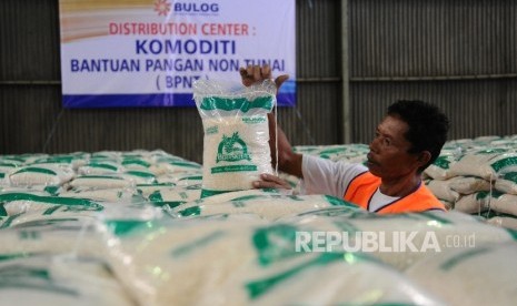 Petugas menata produk Bantuan Pangan Non Tunai (BPNT) Beras Kita dan gula Manis Kita di gudang Bulog.