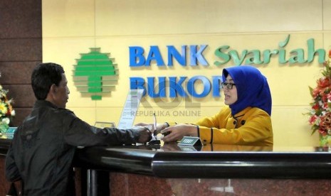 Petugas menata uang nasabah di banking hall salah satu kantor cabang Bank Syariah Bukopin, Jakarta, Senin (25/8).(Republika/Prayogi)