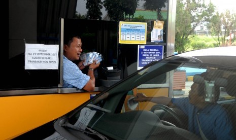 Petugas menawarkan e-money di gerbang pintu tol Jagorawi Citeureup, Kabupaten Bogor, Jawa Barat, Senin (16/10). 