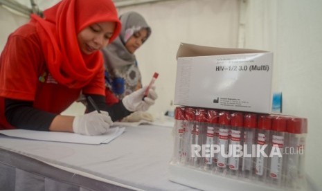 Petugas mencatat identitas darah seorang warga saat pemeriksaan HIV secara gratis 