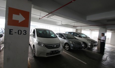 Petugas mencatat nomor polisi mobil yang terparkir di area gedung parkir Plaza Bank Mandiri, Jakarta, Jumat (11/8).