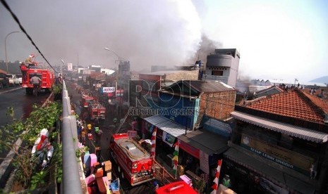 Petugas mencoba memadamkan api yang membakar gudang mebel di Jalan Cimindi, Kota Cimahi, Jumat (21/8). (Foto : Septianjar Muharam)