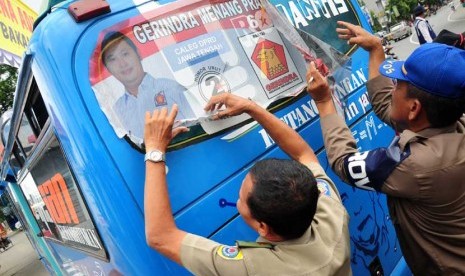  Petugas mencopot stiker calon legislatif (caleg) yang dipasang dikaca angkutan kota (angkot) saat melintas di jalur pantura Jalan Jenderal Sudirman, Brebes, Jateng, Rabu (29/1).    (Antara/Oky Lukmansyah)