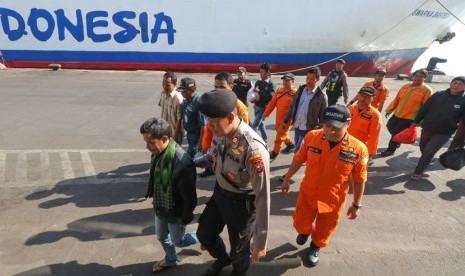 Petugas mendampingi sejumlah korban selamat kapal terbakar KM Santika Nusantara, di dermaga Jamrud Utara, Pelabuhan Tanjung Perak Surabaya, Jawa Timur, Ahad (25/8/2019).