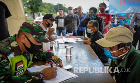 Petugas mendata pemudik yang akan menuju Sumedang di perbatasan Kabupaten Bandung dengan Kabupaten Sumedang di Jatinangor, Kabupaten Sumedang, Jawa Barat, Sabtu (11/4/2020). Pemerintah Kabupaten Sumedang memberlakukan karantina wilayah parsial (KWP) dengan mendirikan posko tim gugus tugas COVID-19 di sejumlah titik perbatasan untuk mencegah penyebaran virus Corona yang mungkin saja dibawa oleh pemudik.