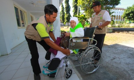 Petugas mendorong calon haji lanjut usia atau lansia menggunakan kursi roda di Asrama haji Embarkasi Banjarmasin, Banjarbaru, Kalimantan Selatan, Senin (8/7/2019). Anggota Komisi VIII Minta Pemerintah Prioritaskan Calon Jamaah Haji Lansia