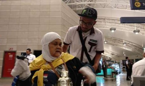 Petugas mendorong jamaah Kloter 41 Embarkasi Jakarta-Bekasi di Bandara Amir Muhammad bin Abdulaziz, Madinah, Ahad (9/9) dini hari. Kloter tersebut merupakan rombongan pertama yang bertolak pulang dalam gelombang kedua kepulangan jamaah haji.