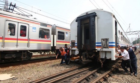 Petugas mendorong Kereta Api (KA) Senja Utama Solo yang mengalami anjlok di Stasiun Tanah Abang, Jakarta, Kamis (10/3).