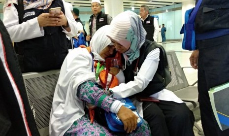  Petugas menenangkankan Asmia Hadi Hasan, seorang jamaah asal Gowa, Sulawesi Selatan, yang ditinggal wafat ibunya di Bandara Amir Muhammad bin Abdulaziz, Madinah, Jumat (20/7).