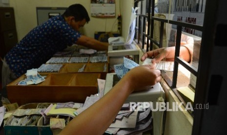  Petugas menerima denda tilang dari pelanggar yang menggunakan aplikasi sidang online di Kejaksaan Negeri Jakarta Barat, Jumat (29/1). (ilustrasi) 