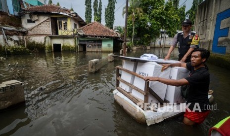 Petugas menerjang banjir dengan menggunakan perahu saat mendistribusikan logistik keperluan Pemilu dan Pileg di Desa Bojongasih, Dayeuhkolot, Kabupaten Bandung, Jawa Barat, Selasa (16/4/2019). 