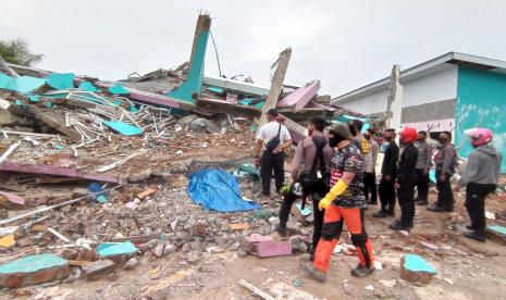 Petugas mengamati bangunan RS Mitra Manakarra yang roboh pascagempa bumi, di Mamuju, Sulawesi Barat, Jumat (15/1).