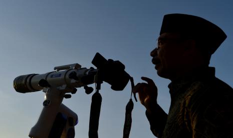 Petugas mengamati posisi hilal menggunakan teropong saat pelaksanaan Rukyatul Hilal di Pantai Jerman, Kuta, Badung, Bali, Rabu (29/6/2022). Pengamatan posisi bulan yang dilakukan untuk menentukan awal bulan Zulhijah dan Idul Adha 1443 H/2022 M di pantai tersebut tidak berhasil melihat hilal karena kondisi cuaca berawan serta ketinggian hilal yang masih terlalu rendah. 