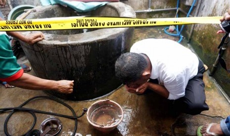 Petugas mengambil air di dalam sumur milik Mudrikatin yang berubah menjadi panas di Desa Ngemplak, Perak, Jombang, Jawa Timur, Senin (1/12).     