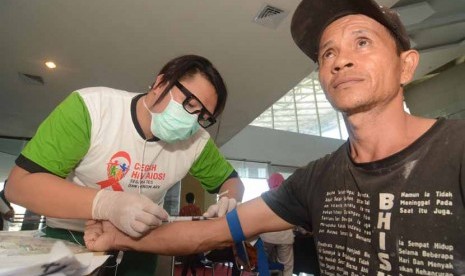 Petugas mengambil sampel darah seorang warga untuk diperiksa terkait pencegahan HIV/AIDS di Palu, Sulawesi Tengah, Senin (1/12). 