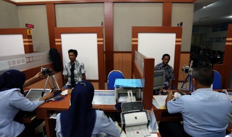 Petugas mengambil sidik jari pemohon paspor haji di kantor imigrasi (Ilustrasi)