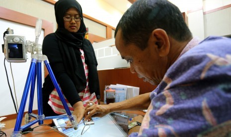 Petugas mengambil sidik jari pemohon paspor di Kantor Imigrasi Klas II Blitar, Jawa Timur, Kamis (24/3).