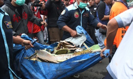 Petugas mengangkut puing-puing pesawat latih tempur Super Tucano yang jatuh di permukiman warga di Jalan LA Sucipto, Malang, Jawa Timur, Rabu (10/2). 