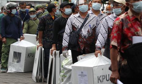 Petugas mengantre untuk mengembalikan logistik hasil Pilkada Kota Surabaya di Kantor Kecamatan Kenjeran, Surabaya, Jawa Timur, Rabu (9/12/2020). Setelah dilakukannya penghitungan suara di setiap Tempat Pemungutan Suara (TPS), logistik Pilkada Kota Surabaya 2020 diserahkan ke Panitia Pemilihan Kecamatan (PPK).