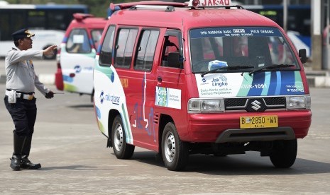 Petugas mengatur arus kendaraan angkutan kota (Angkot) di Terminal Bus Terpadu Pulogebang, Jakarta Timur, Jumat (2/8/2019).