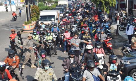 Petugas mengatur arus lalu lintas di Jalan Urip Sumoharjo saat dilakukan seleksi pengendara yang akan memasuki wilayah di Kota Madiun, Jawa Timur, Kamis (2/4/2020). Petugas menolak pengendara yang bukan warga kota Madiun memasuki wilayah tersebut yang dimaksudkan untuk mengurangi pergerakan masyarakat dari luar daerah di wilayah itu untuk mencegah penyebaran COVID-19 atau virus Corona.