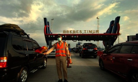 Petugas mengatur kendaraan ketika antre pintu masuk tol Brebes Timur, Jawa Tengah, Rabu (28/6). 