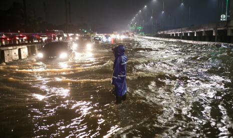 Petugas mengatur lalu lintas saat banjir di ruas Tol Pondok Aren-Serpong, Kota Tangerang Selatan, Banten, Selasa (4/10/2022). Menteri PUPR Basuki Hadimuljono akan mengevaluasi tol tersebut karena kerap terjadi banjir yang disebabkan oleh sistem drainase yang buruk. 