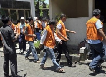 Petugas mengawasi sejumlah tahanan yang digiring dari Lembaga Pemasyarakatan (Lapas) Kerobokan untuk menjalani sidang di Pengadilan Negeri Denpasar, Bali, Senin (27/2). Aktifitas peradilan bagi tahanan yang dititipkan di Lapas terbesar di Bali itu mulai di