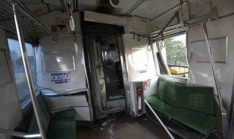 Petugas mengecek gerbong yang rusak akibat tabrakan Kereta Rel Listrik (KRL) di Stasiun Juanda, Rabu (23/9). 