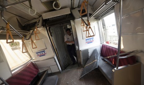 Petugas mengecek gerbong yang rusak akibat tabrakan Kereta Rel Listrik (KRL) di Stasiun Juanda, Rabu (23/9).