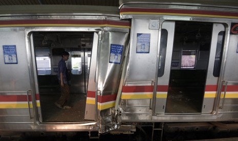 Petugas mengecek gerbong yang rusak akibat tabrakan Kereta Rel Listrik (KRL) di Stasiun Juanda, Rabu (23/9). 