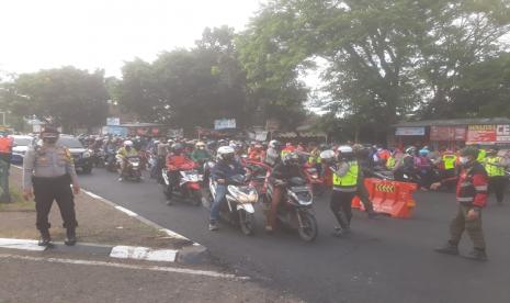 Petugas mengecek kelengkapan surat-surat kepada pengendara roda dua dan empat di posko penyekatan di Cibiru perbatasan Kota Bandung-Kabupaten Bandung di masa PPKM Darurat, Kamis (15/7).