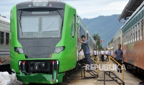 Petugas mengecek kondisi Kereta Rel Diesel Elektrik (KRDE) Bandara Internasional Minangkabau (BIM), seusai membuka pembungkus terpal, di Stasiun Simp Haru, Padang, Sumatera Barat, Jumat (23/2).