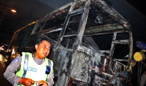  Petugas mengevakuasi bangkai Bus Transjakarta jurusan Blok M-Kota yang terbakar di Jl Jenderal Sudirman, tepat di bawah jembatan Semanggi, Jakarta, Senin (5/11) malam. (Yasin Habibi)