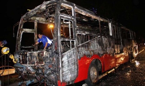  Petugas mengevakuasi bangkai Bus Transjakarta jurusan Blok M-Kota yang terbakar di Jl Jenderal Sudirman, tepat di bawah jembatan Semanggi, Jakarta, Senin (5/11) malam. (Yasin Habibi)