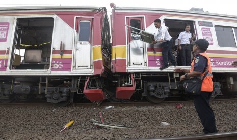 Petugas mengevakuasi barang barang yang ada di gerbong ketika terjadi tabrakan Kereta Rel Listrik (KRL) di Stasiun Juanda, Rabu (23/9).