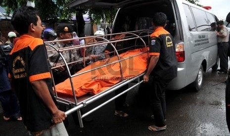 Petugas mengevakuasi jenazah bernama Sadim (34) kelahiran Majalengka di bawah Jembatan kereta Matraman, Jakarta Timur, Jumat (17/1).  (Republika/Prayogi)