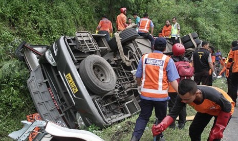 Petugas mengevakuasi korban bus terguling.