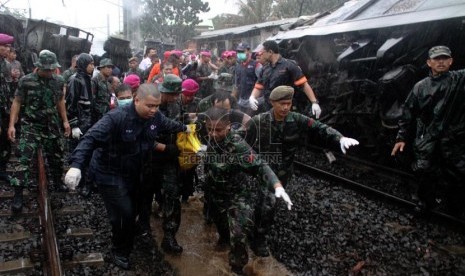  Petugas mengevakuasi korban kecelakaan kereta rel listrik di perlintasan kereta di Bintaro Permai, Tangerang, Senin (9/12).  (Republika/Yasin Habibi)