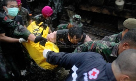 Petugas mengevakuasi korban kecelakaan kereta rel listrik di perlintasan kereta di Bintaro Permai, Tangerang Selatan, Senin (9/12). (Republika/Yasin Habibi)