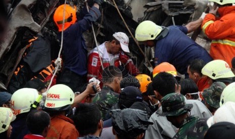 Petugas mengevakuasi korban kecelakaan kereta rel listrik di perlintasan kereta di Bintaro Permai, Tangerang Selatan, Senin (9/12). (Republika/Yasin Habibi)