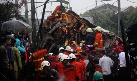 Petugas mengevakuasi korban kecelakaan kereta rel listrik di perlintasan kereta di Bintaro Permai, Tangerang Selatan, Senin (9/12). (Republika/Yasin Habibi)