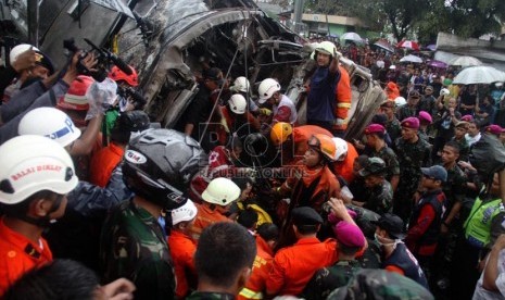 Petugas mengevakuasi korban kecelakaan kereta rel listrik di perlintasan kereta di Bintaro Permai, Tangerang Selatan, Senin (9/12). (Republika/Yasin Habibi)