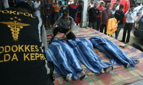 Petugas mengevakuasi korban meninggal tenggelamnya kapal yang mengangkut sejumlah tenaga kerja Indonesia (TKI) di Teluk Mata Ikan, Batam, Kepulauan Riau, Selasa (2/11). 