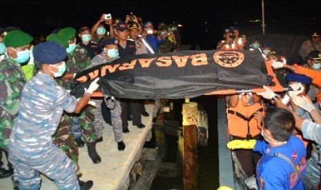 Petugas mengevakuasi korban pesawat AirAsia QZ8501 dari KP Sadewa di Pelabuhan Panjang, Kotabaru, Jumat (16/1) malam.