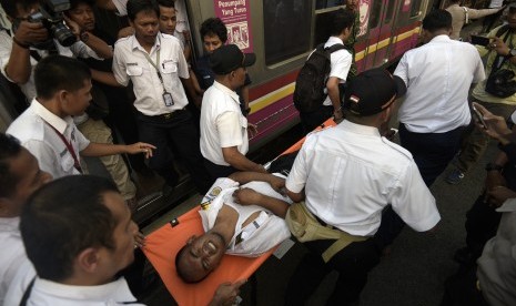 Petugas mengevakuasi masinis yang menjadi korban tabrakan Kereta Rel Listrik (KRL) di Stasiun Juanda, Rabu (23/9). T